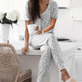 Women's V-NeckLeopard Print Loungewear Set. This relaxed-fit two-piece features a short-sleeve top and pants for effortlessly chic, casual comfort.